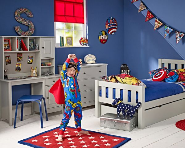 Boy pretending to be a superhero in his bedroom
