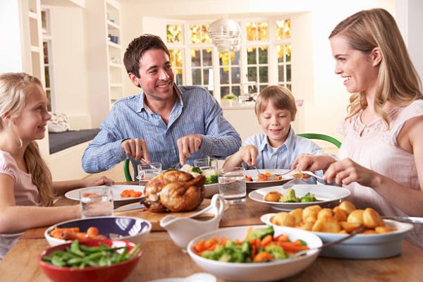 Happy family having roast chicken dinner at dining table