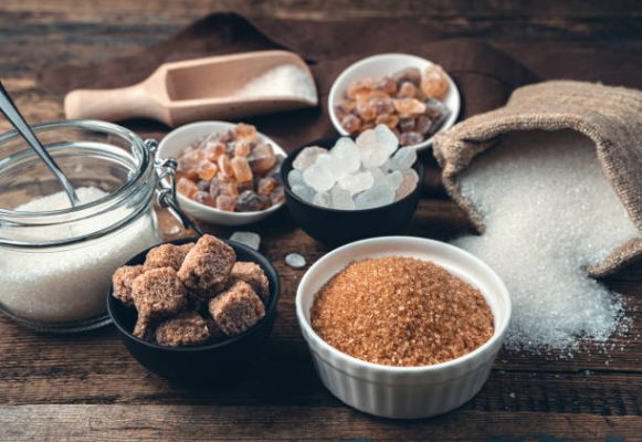 Many different types of sugar on a wooden background. Side view.