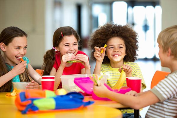 Group of children having packed lunches