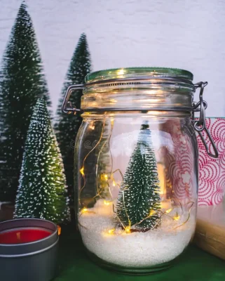 A small fake tree with fake snow in a jar