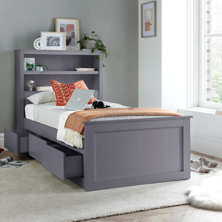 he Enzo Grey Wooden 3 Drawer Storage Bed is a super cool and useful bed that saves space! It's a single bed made of strong Rubberwood with a white finish, so it looks great in any room. It has three big drawers built-in – perfect for storing bedding, clothes, or whatever. Plus, the headboard has two bookshelves for your books or stuff you need at night. You can put the drawers on either side, which is awesome if your room is small or you're just sleeping solo.