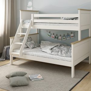 The Kids Avenue Heritage triple bunk bed features a white frame with oak detailing and a reversible three-step slanted ladder. Constructed from Scandinavian pine, it's designed for multiple children sharing a room. The top bunk has two front safety rails, two full-length back safety rails, and requires a UK single mattress (90cm x 190cm). The bottom bunk accommodates two children and requires a UK double mattress (140cm x 190cm). The sturdy three-step ladder can be assembled on either the left or right front side of the bed. Both beds include solid wooden slats, high headboards and footboards, and an oak top rail that complements the white frame.